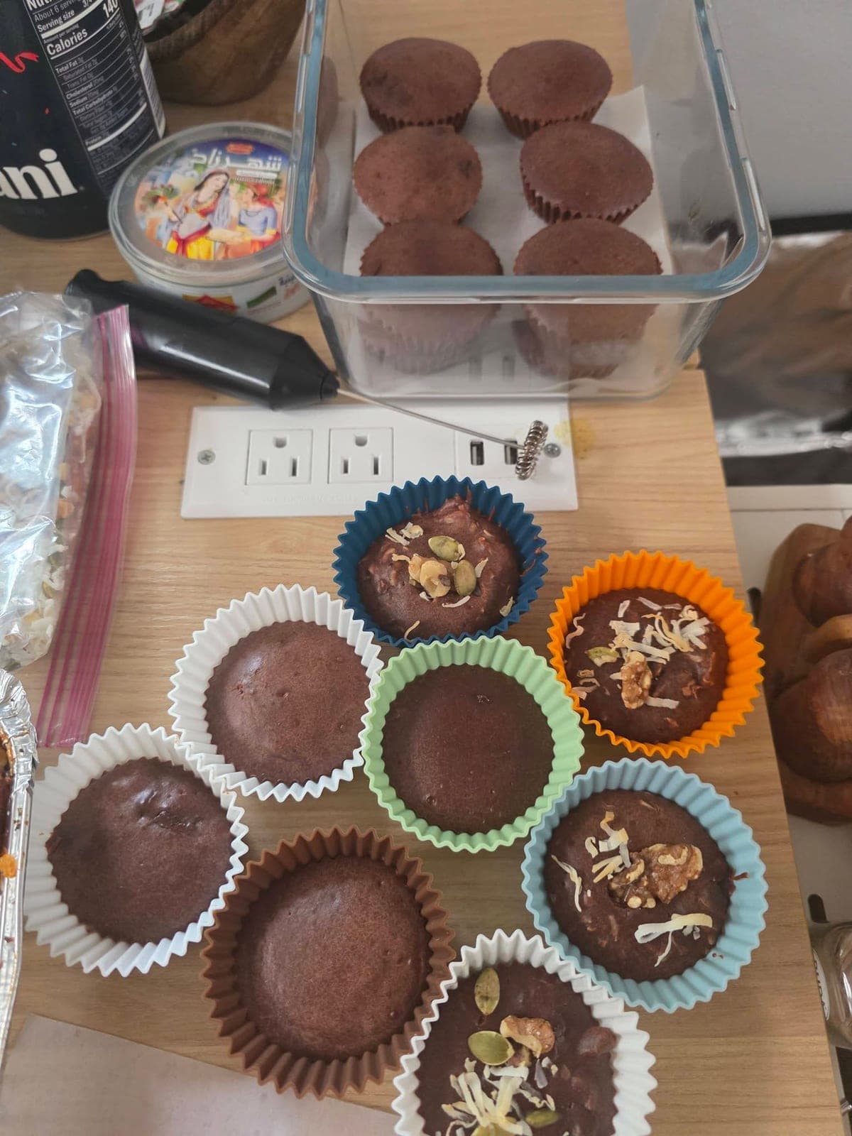 Brownies in paper cups, some topped with sliced almonds.